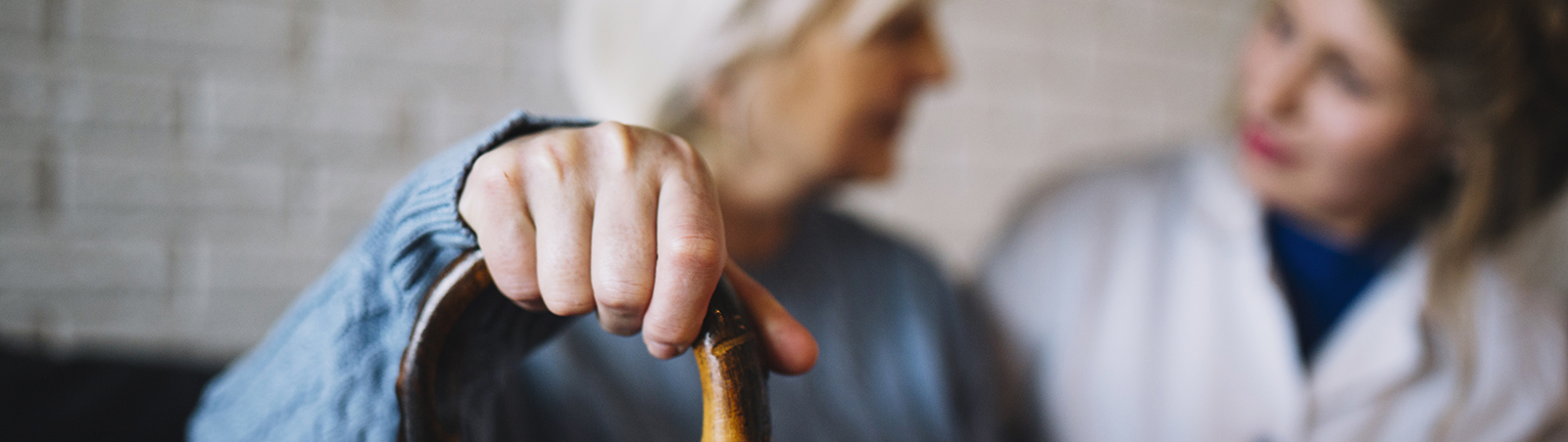 Mano anziana su bastone di appoggio